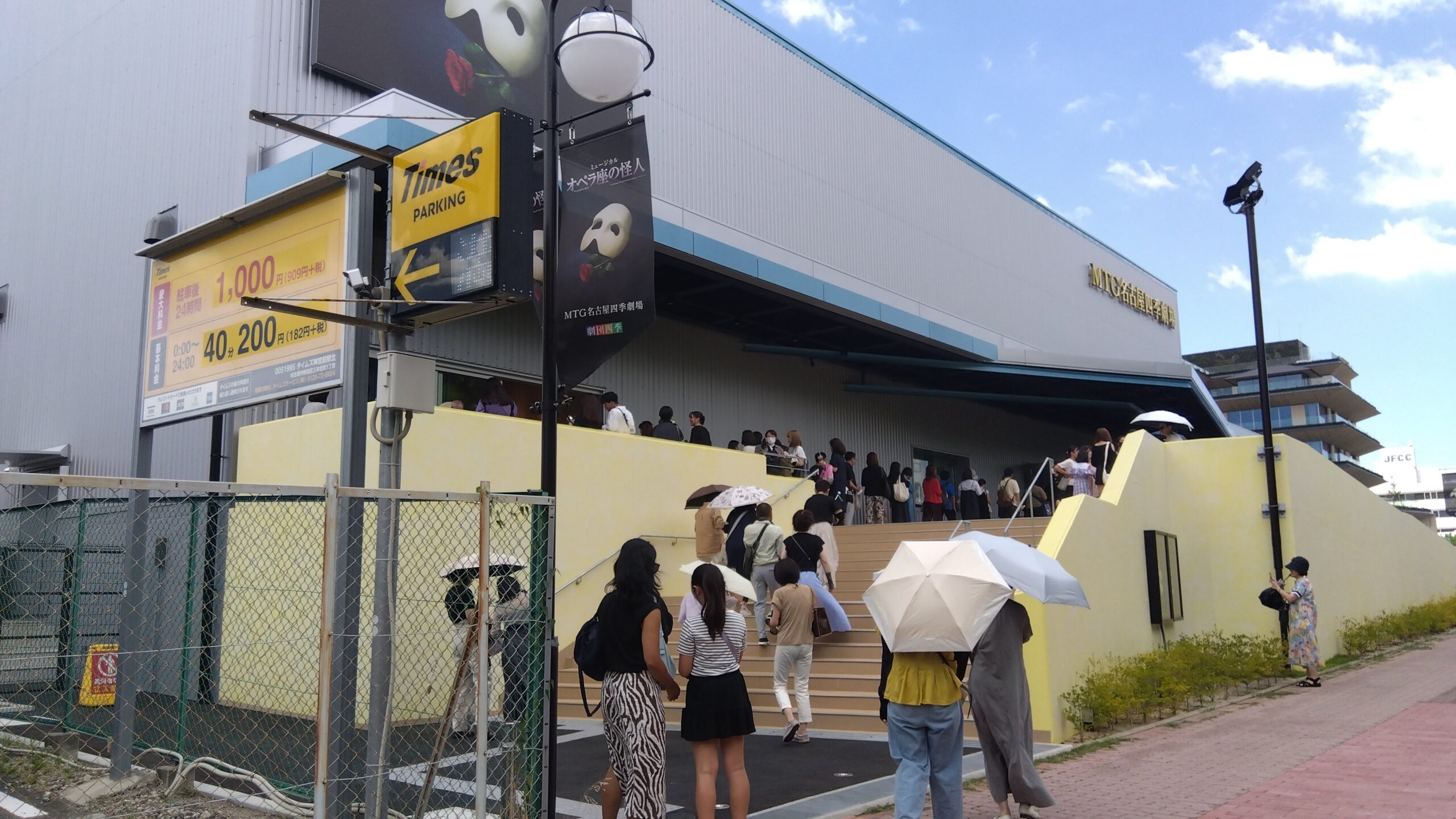 MTG名古屋四季劇場の外観とTimesパーキングの看板、入場を待つ人々