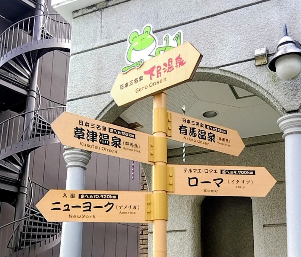 下呂温泉・草津温泉・有馬温泉・ローマ・ニューヨークの方向を示すユニークな道標
