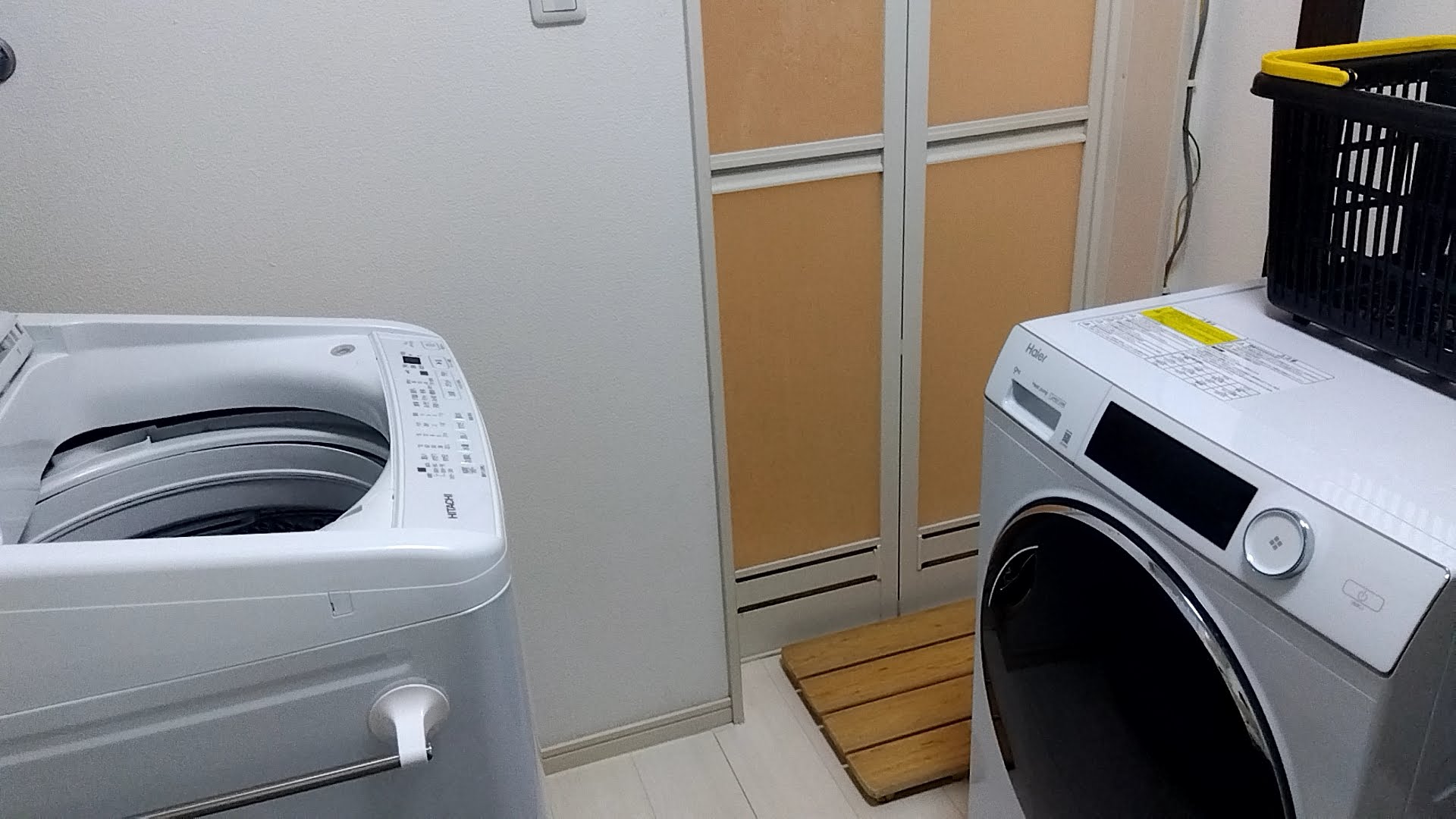 左に縦型洗濯機、正面にお風呂の入口、右にFUWATOを置いた脱衣所